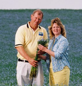 Mark and Esther Hylden in front of e Blooming Field of Flax