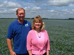 Mark and Esther Hylden in a blooming field of flax